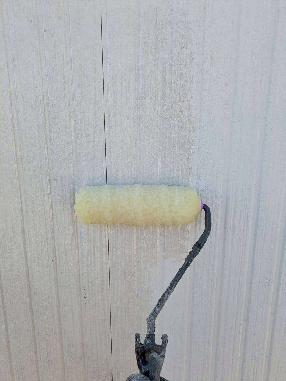 白い外壁にプライマーを塗布